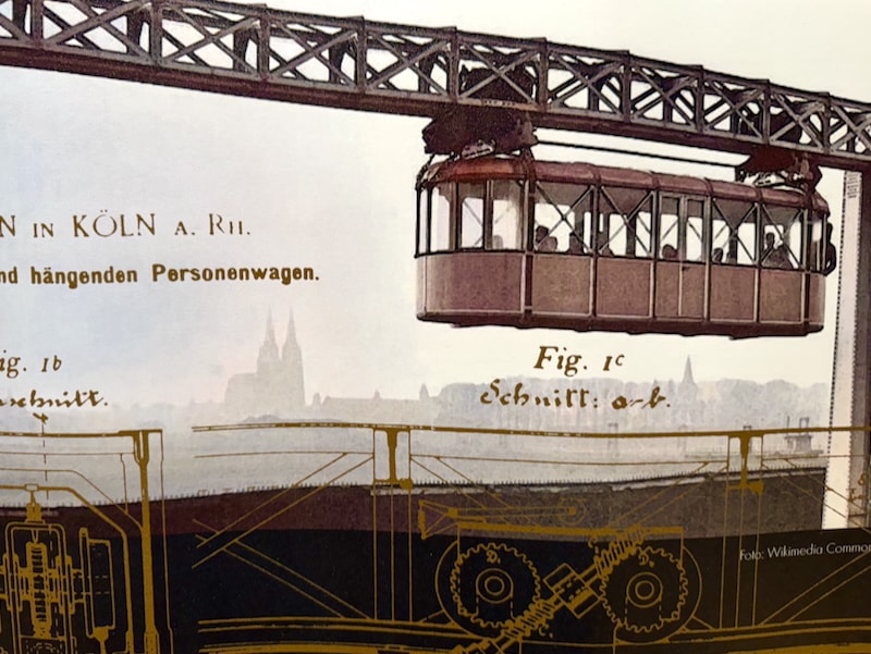 Historic photo of a wagon on the Wuppertal suspension railway above a city skyline, overlaid with cog and wheel illustrations; Schwebodrom Museum, Wuppertal.